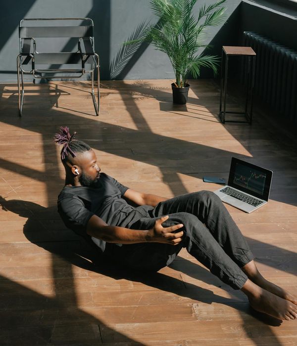A person stretching gently by a large window, symbolizing well-being.