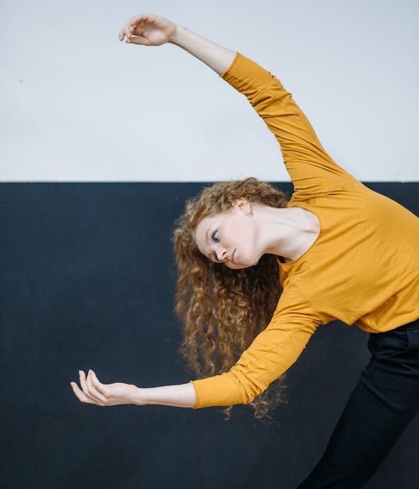 A silhouette of a person in a dynamic and fluid stretching pose.
